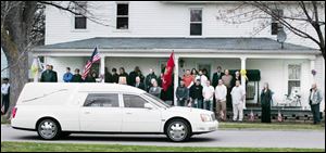 The hearse carrying his body passes his Green Springs home.
