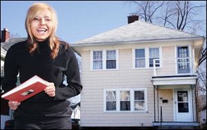 Toledoan Schylar Meadows stands in front of her home holding the book Home: The Blueprints of Our Lives, which contains her essay.