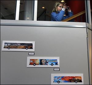 Christina Stanley, 12, photographs some of the award-winning designs and poetry that is being displayed on buses. TARTA and the Arts Commission of Greater Toledo sponsored the contest.