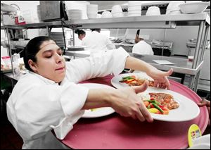 Jennifer Vasquez, who hopes to own a restaurant someday, loads a tray. 