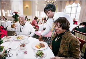 Trainee LaTonya Holmes serves Corey Allison, left, and Crystal Harris in the Park Lane dining room. 