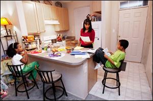 Karen Sanders goes over homework with Clarke, left, and Aidan. She often falls back on mother's intuition and the advice of her grandmother, who had a second-grade education.