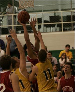 Bedford s Joshua Albright takes a shot over Whiteford s Cody McCartney and Austin Dickerson (11) in the Warrior Classic.