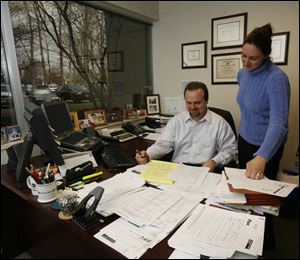 Jeff Brubaker and Jennifer Bryant work with client documents. The firm serves medium-to-large, privately owned companies as well as several publicly owned companies in the region. 