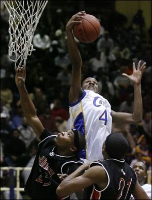 Libbey's William Buford takes the ball to the hoop against Canton McKinley's Morgan Williams, left, and Lonnie Richardson. Buford led the Cowboys last night with 31 points and 10 rebounds as Libbey knocked off the third-ranked Bulldogs. The Cowboys improved to 11-1 on the season.