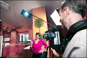 Zonya Foco tapes her show, Zonya's Health Bites, in her home kitchen. Her husband, Scott, is the cameraman.