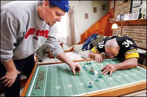 Phil Gilliam, left, and Greg Hardmon with Mr. Hardmon s electric football game in West Toledo.  It s actually like playing chess, 
Mr. Hardmon says of the game that he loved as a youth.  It s very strategic in how you play. 