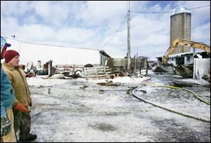 David Hermes surveys the damage after a barn fire yesterday near Sandusky. All 100 of the milking cows were removed and within hours were taken to a dairy farm near Vickery, Ohio, as neighbors pitched in.