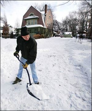 Pat Ferris shovels his driveway on Robinwood Avenue in Toledo s Old West End.
