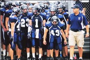 Brad Heinrichs (43) gets ready to lead Napoleon onto the football field. And coach John Snoad arranged a surprise finale.