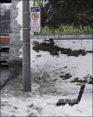 Snow and ice nearly bury a bench where Toledo Area Regional Transit Authority riders wait for the bus on Bancroft Street at Westwood Avenue. Residents and businesses have 24 hours to clear their sidewalks, according to city code, but that s not what many pedestrians are seeing as some of last week s heavy snowfall continues to make
getting around difficult.