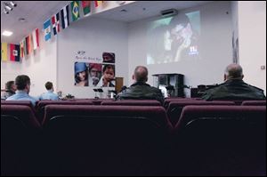 Firefighters and police offi cers watch the funeral on a church TV screen. Toledo s four television
stations broadcast the funeral, but two ended coverage early because of technical problems.