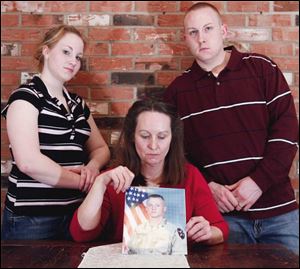 Darlene Keil displays a photo of her son Matthew. Lending support are her daughter, Amanda, 15, and son Deken, 27. Sergeant Keil is at Walter Reed Army Medical Center.
