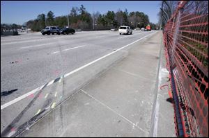 Plastic netting replaces the fence where a bus crash in Atlanta killed six people, including four Bluffton University athletes.