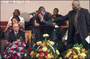 Alonzo Williams, left, breaks down after reading about Bluffton baseball player Tyler Williams during the 19-year-old's funeral at the Philippian Missionary Baptist Church in Lima, Ohio. 
