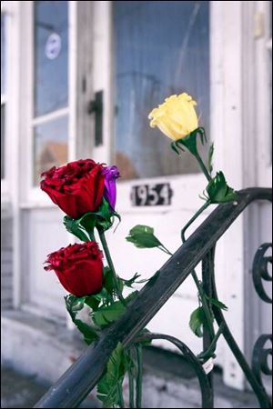 Roses have been tucked into a front-porch railing at the Burr Street home where a fire killed an 8-year-old girl yesterday.
