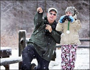 Bob Hinkle of Cleveland Metroparks helps Bridgett Mahoney, 9, look for buzzards in Hinckley, Ohio. Dozens of enthusiasts watched and waited in the morning chill for the first 'official' spotting. 