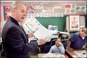 Gov. Ted Strickland reads a book by Keyser Elementary students during his stop in Toledo to promote his spending proposal.
