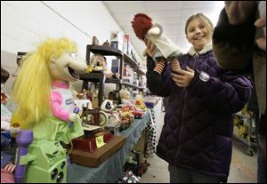 Taylor Werner, 9, of Alvada, Ohio, shows a Raggedy Ann doll she likes to her grandmother. The pair had three buildings to explore, where 235 tables were filled with merchandise.