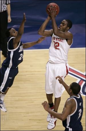 Ohio State senior Ron Lewis shoots over Xavier's Drew Lavender to tie the score with two seconds left in regulation.