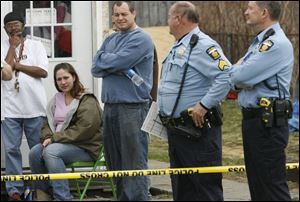 Tanya Emerson, who is seated, found 13-month-old Jordan Calhoun face-down in a plastic tub on the front porch of her father's home at 512 Albany St.