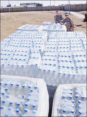 Bottles of water arrive in huge, blue cubes bundled into thousand-bottle units by a 5-foot roll of industrial cling wrap. This water is processed in a plant on the edge of base, and it is distributed by racing forklifts.