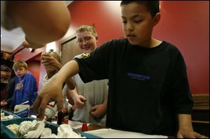 Dalton Hicks, left, watches Brandon Lee put the finishing touches on the sundae with a puff of whipped cream.