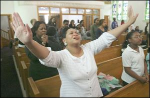 Carolyn Hobbs raises her hands in prayer at a recent Wednesday evening service at Upton United Methodist Church.