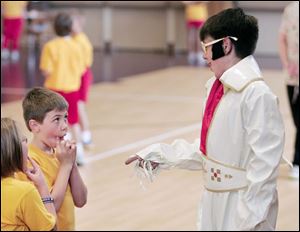 First grader Ezra Baden, 8, casts a wary look at Casey Horn, 13, who portrays Elvis Presley.