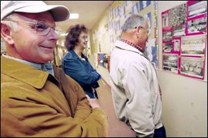 Cleo Mominee, from left, Joan Row, and Walter Humberger look over a collage of some of the old school photographs that were displayed during the open house at Coy Elementary School. The three lifelong friends were Coy classmates since kindergarten.