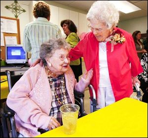FLorence Kanipe, 90, left, and Lynda Myers visit at a party to celebbrate Ms. Myers' 100th birthday.