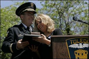Police Chief Mike Navarre embraces Danielle Dressel at a ceremony during which the late detective s badge was retired.