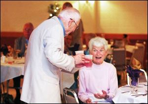 Harold Wolff, far left, offers a beverage to Dorothy Whitacre at the 62nd reunion of Waite's class of 1945. 