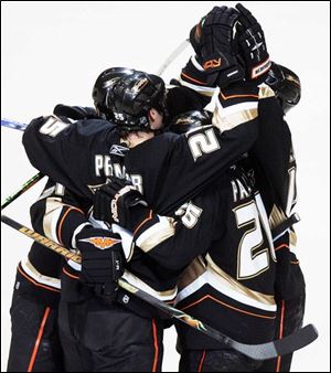 Ducks center Rob Niedermayer, back right, is mobbed by teammates after scoring a goal in the first period last night as Anaheim beat Detroit to advance to the Stanley Cup finals.