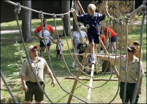 Scouts of all ages and sizes were in action at the Camp Miakonda event. Cub Scout Jared Thornton of Pack 332 walks across the monkey bridge under close supervision of older scouts.
