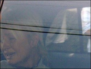 Paris Hilton weeps in a police car as she is taken from her Hollywood Hills home to Los Angeles County Superior Court.
