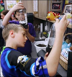 Colton Wagner, front, and Sam Hooper look at worm farms.