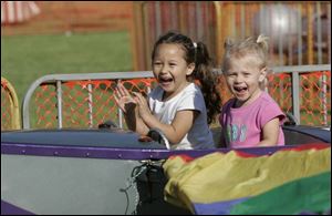 Hannah Keuerleber, 4, left, and her sister, Victoria, 2 , of Grove City, Ohio, have fun on the boat ride at the Cherry Festival.
