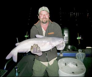 Chip Hart of Batavia, Ohio, hoists a 10-pound blue catfish he took on a recent excursion on the Ohio River.