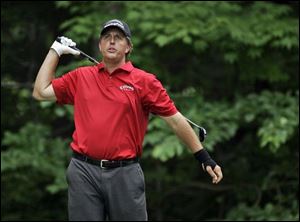 Phil Mickelson appears to be swinging with one arm. He said he was releasing his left hand early to avoid hurting his wrist. The sand flies as Tiger Woods hits out of the sand trap at the 
No. 8 hole during the opening round of the U.S. Open. Fred Funk hits onto the green at No. 8 in U.S. Open play at Oakmont yesterday. He also observed his 51st birthday.
