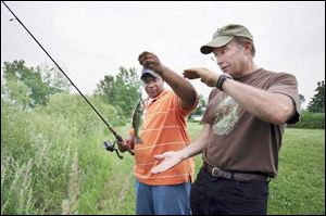 Justin Baker, left, and his Big Brother Gerry Kane, have fun catching largemouth bass at Mr. Kane s Ottawa Lake, Mich., home.