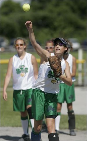 Olivia O Reilly throws a softball while warming up with her
Lady Irish 13U team at Rolf Park in Maumee. She was diagnosed with asthma two years ago, but never gave up sports.