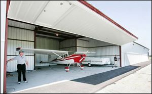 Airport Manager Mike Hodges closes a stall in the new hangar at the Wood County Regional Airport in Bowling Green. The hangars were built to replace hangars that were damaged by a storm a year ago. The airport is compiling a list of interested tenants in case there is enough demand to build a third hangar.