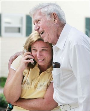 A relieved Kerry Katafiasz celebrates with neighbor Cecil McCourt, who alerted Ms. Katafiasz's daughter to a fire. 'It was lucky that the neighbor did knock on that door,' Battalion Chief Frank Keating said.