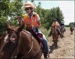 Near a wooded dry stream bed in Plain Township, volunteer Cathy Gough of the Central Ohio Mounted Search Unit looks for clues to the disappearance of 26-year-old Jessie Marie Davis.