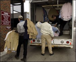 Volunteers unload a truck of clothing and carry it into the Cherry Street Mission s donated clothing shop. The mission offers rehabilitative services as well as food, shelter, and clothes.
