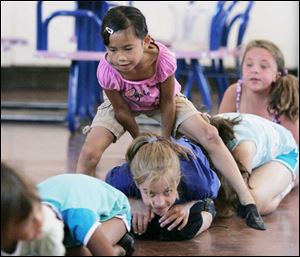 At right, Hannah Lagger, 7, of Lambertville takes a big hop and passes over Madison Monroe, 9, of Temperance. 
