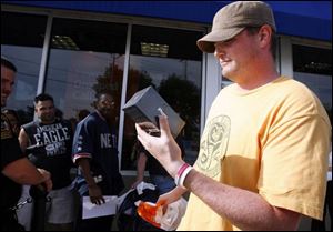 Jamie Wright of Sylvania emerges as the first to buy the
phone at the AT&T store on Monroe Street. He said he was
in line about 5 a.m., five hours before opening time.