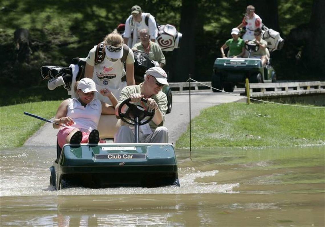 Golfer Kelli Kuehne and her caddie get a ride to the green on No. 2 from operations chairman Dick Flaskamp during the second round of last year s Farr Classic.