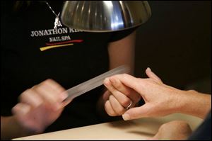 Technician Elise Lark, gives Tami Caito a manicure. 